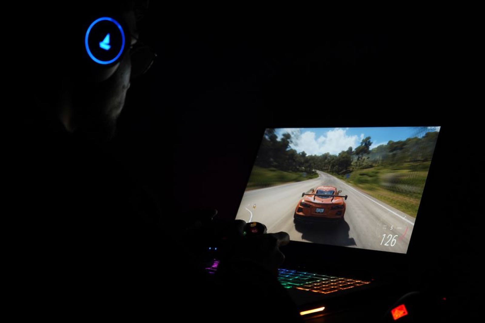 A gamer playing on a laptop with headphones