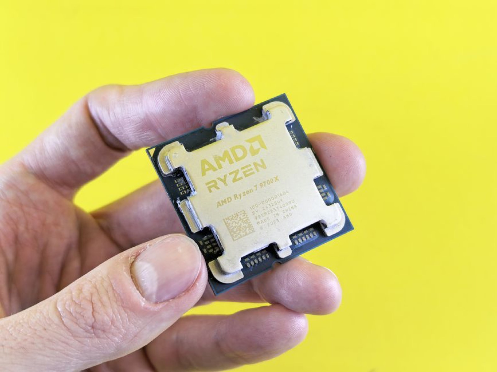 An AMD Ryzen processor held between two fingers