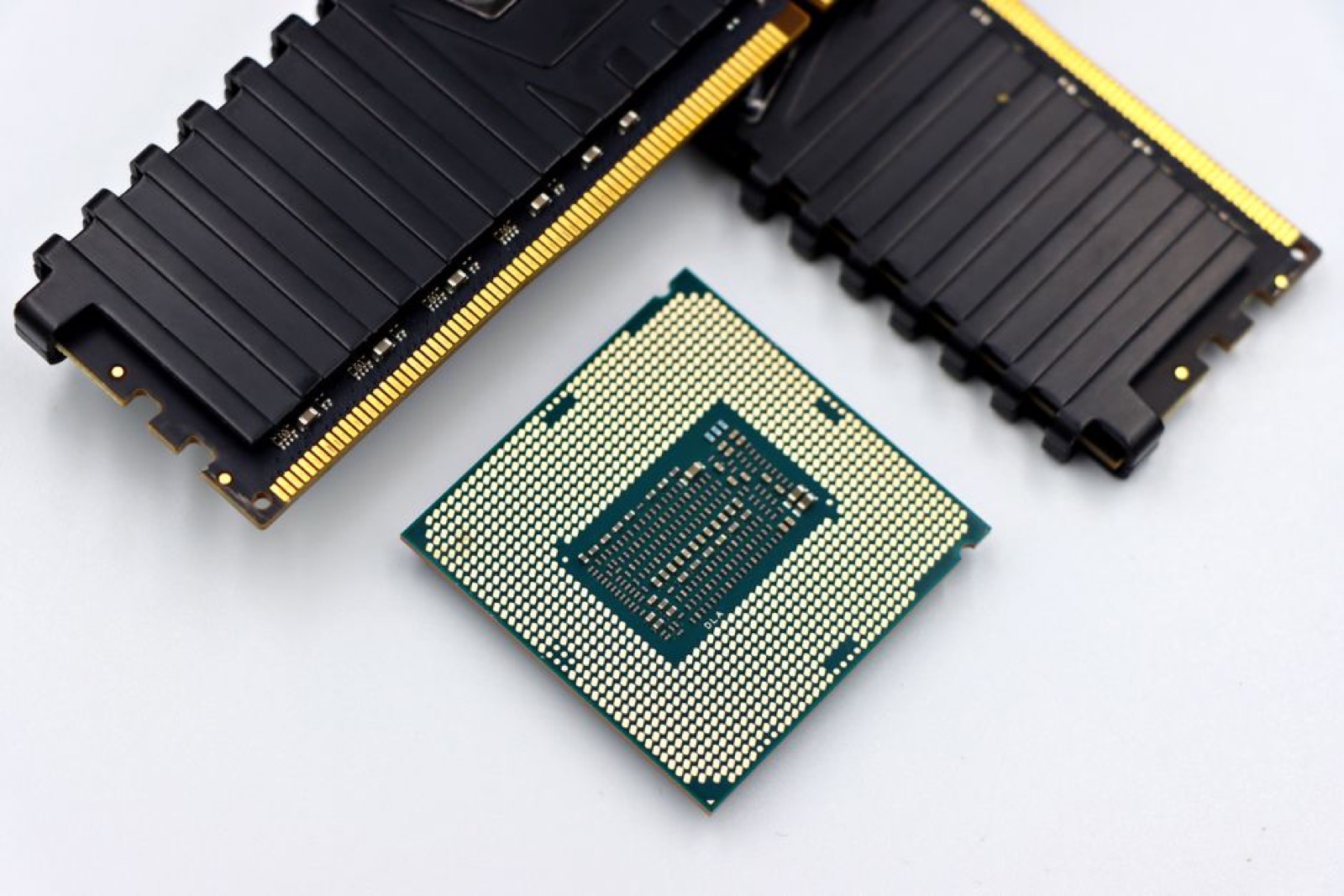 A CPU and RAM sticks on a white surface