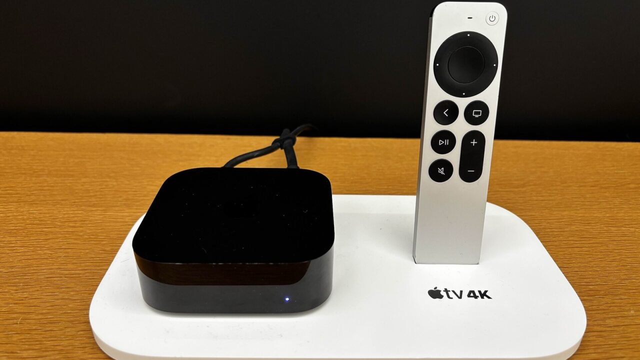 An Apple TV 4K and its Siri Remote on a display stand
