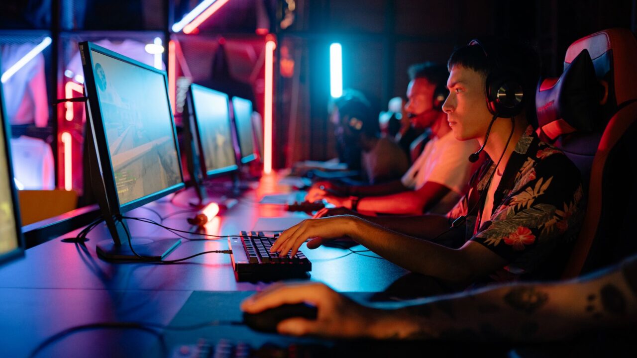 Group of gamers immersed in competitive esports at a cyber arena with neon lighting.