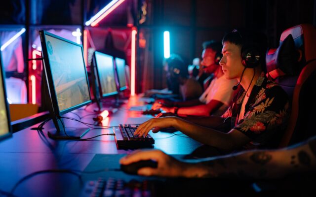 Group of gamers immersed in competitive esports at a cyber arena with neon lighting.