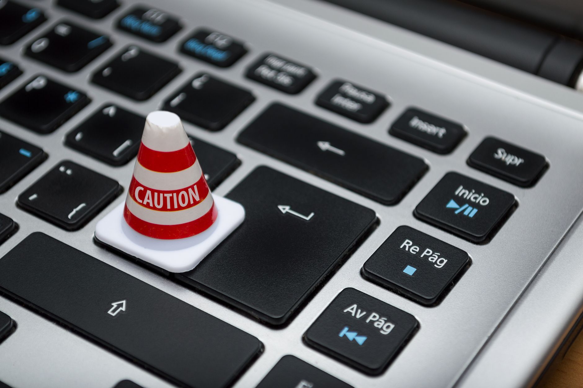 A small caution cone on a laptop keyboard