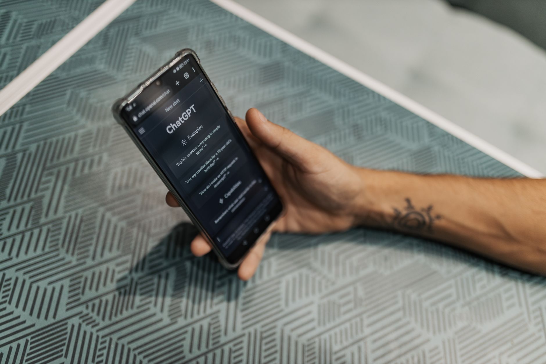 A hand holding a smartphone with the ChatGPT app open