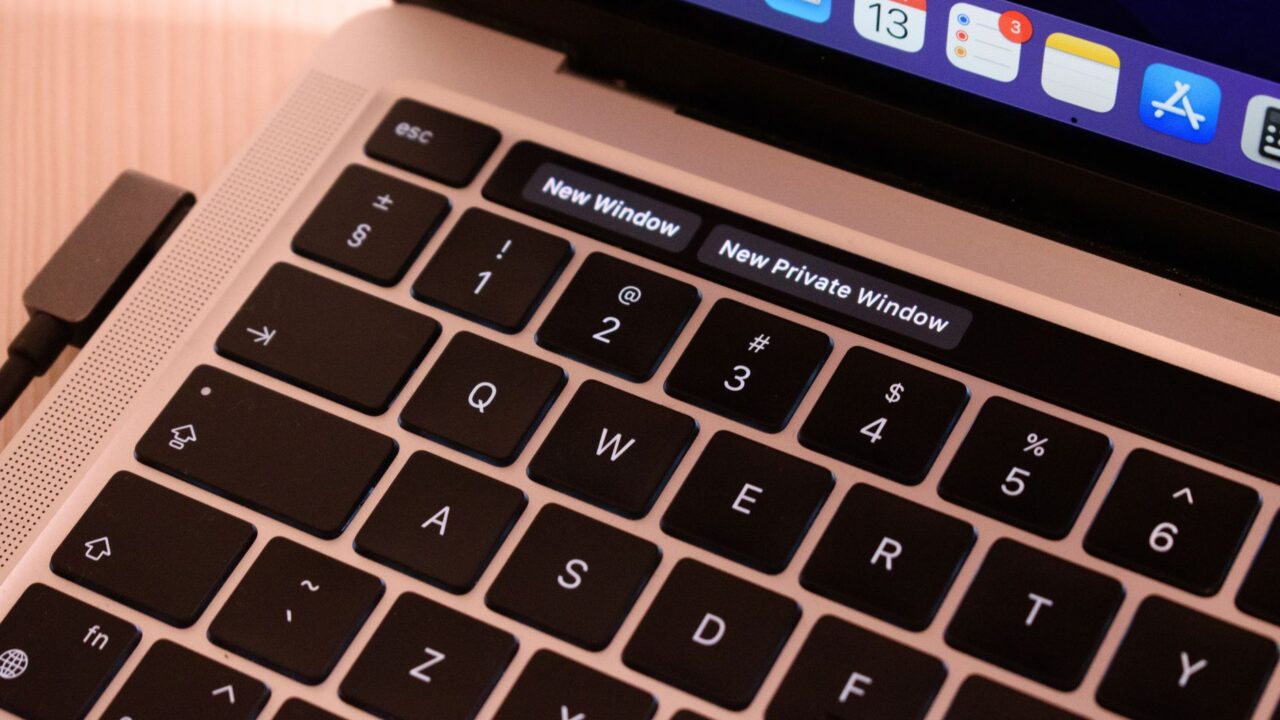 A detailed view of a laptop keyboard with browser tabs open, highlighting 'New Window' and 'New Private Window'.