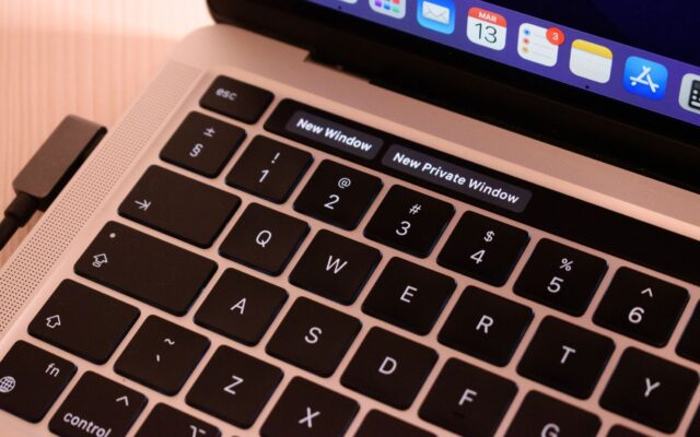 A detailed view of a laptop keyboard with browser tabs open, highlighting 'New Window' and 'New Private Window'.