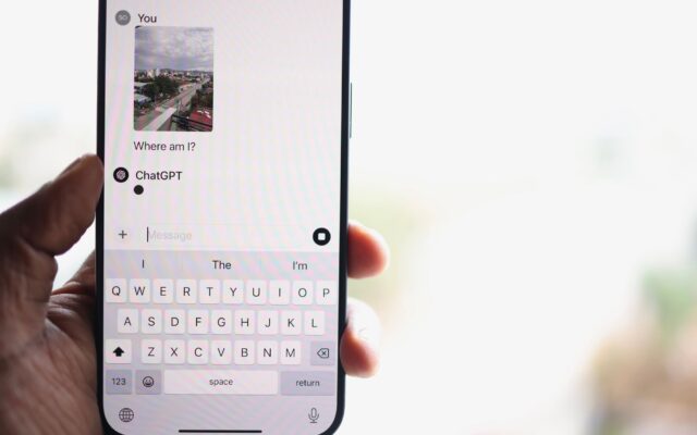 A person holding an iPhone with a ChatGPT conversation on screen