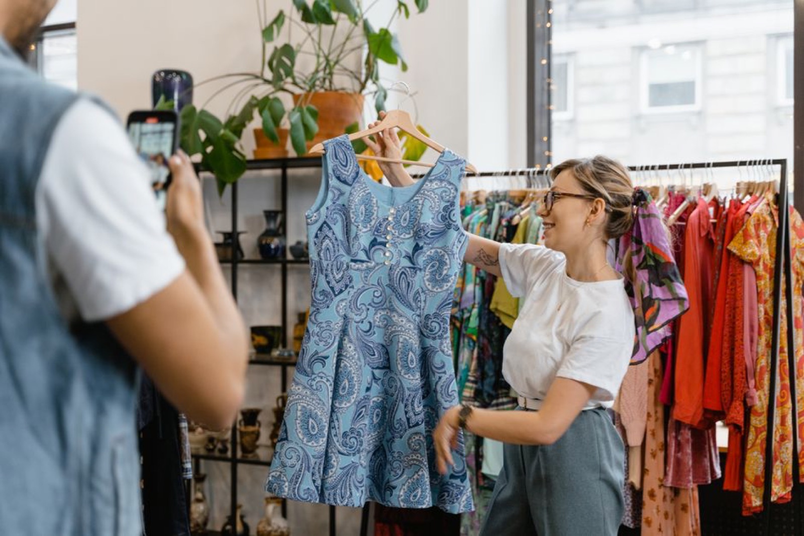 A woman showing a blue dress in a store