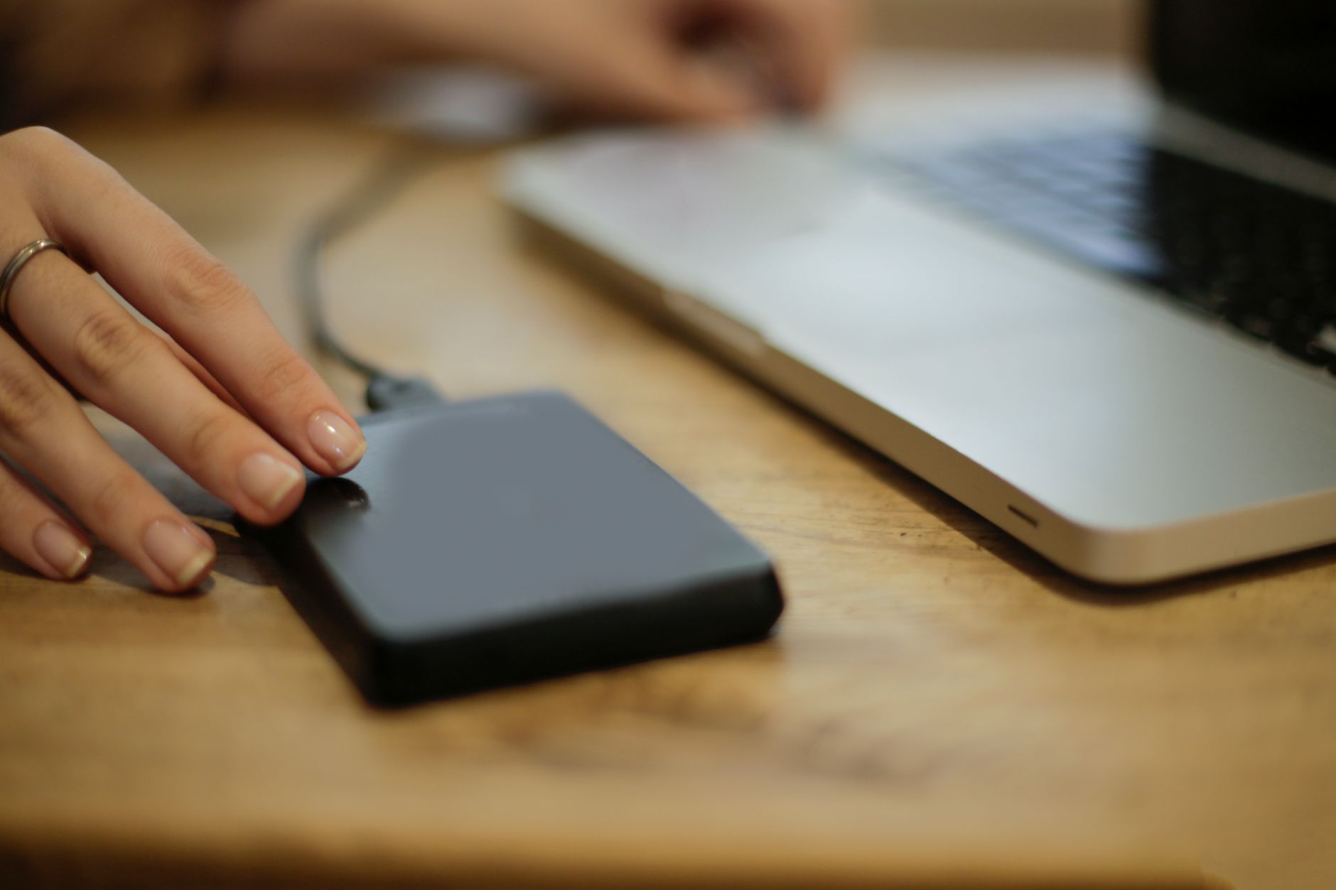 A person connecting an external hard drive to a laptop