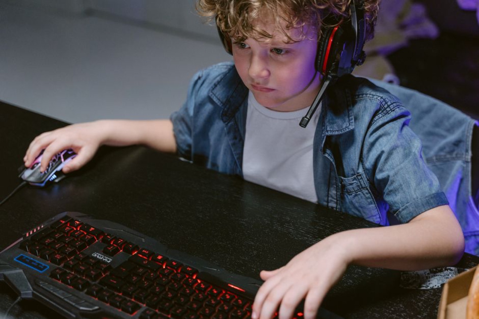 A young child using a keyboard and mouse