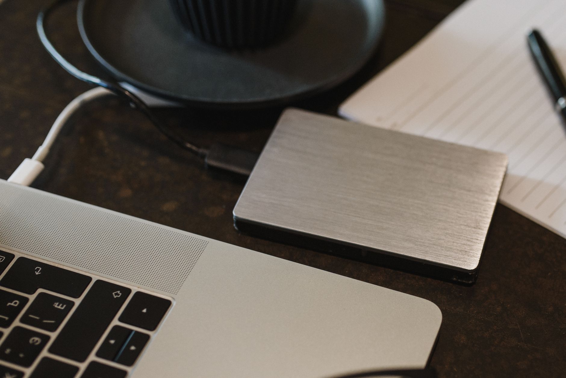 An external hard drive connected to a laptop on a desk
