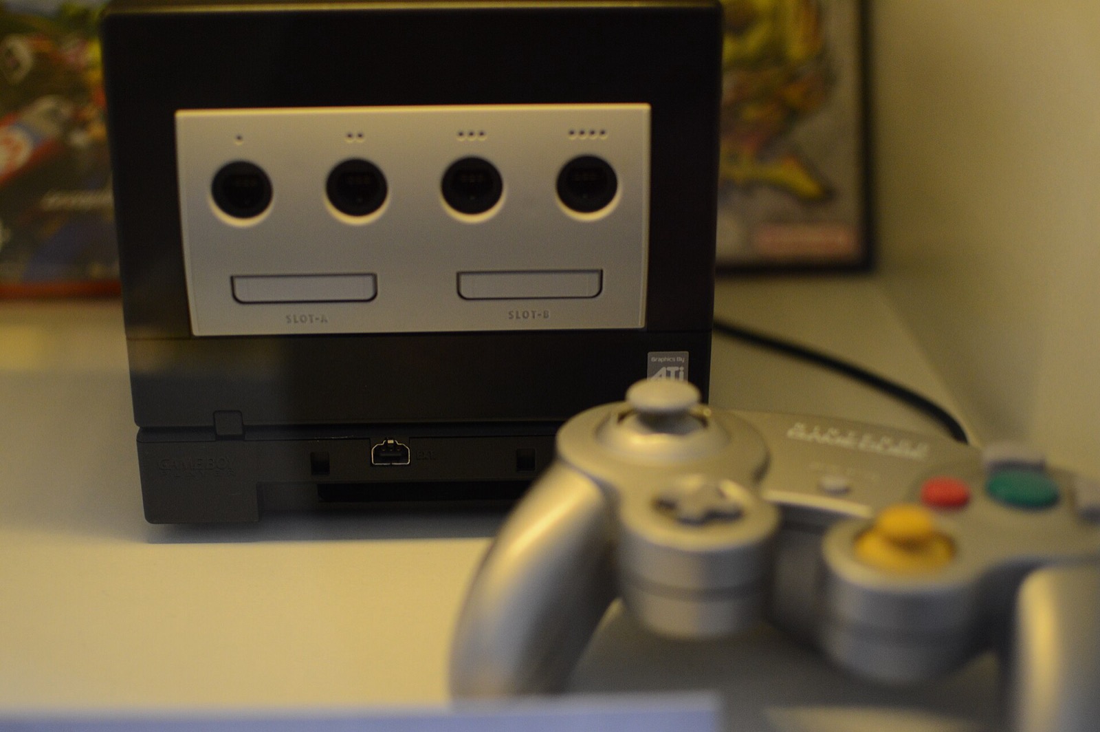 A black GameCube and controller on display in a museum