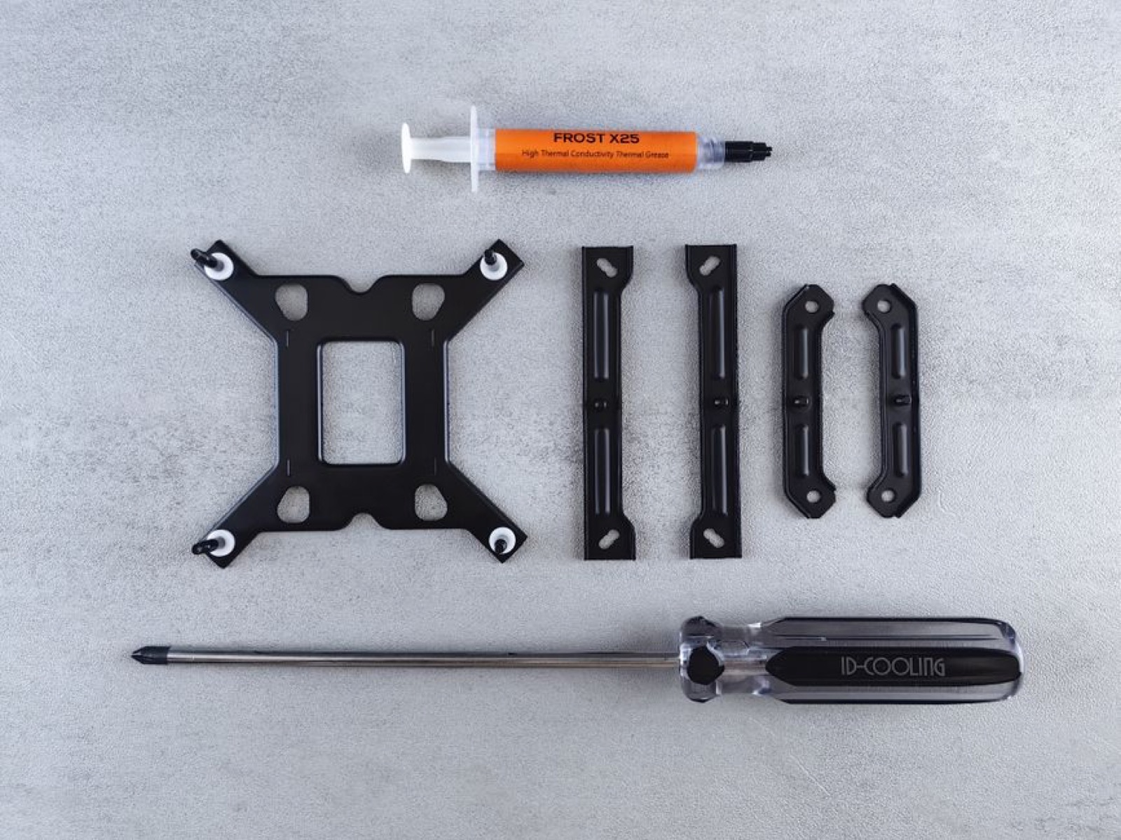 CPU cooler mounting kit laid out with a screwdriver