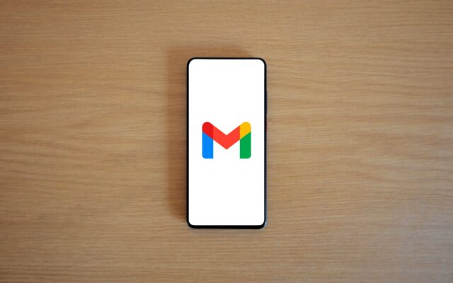 A smartphone showing the Gmail logo on a wooden table