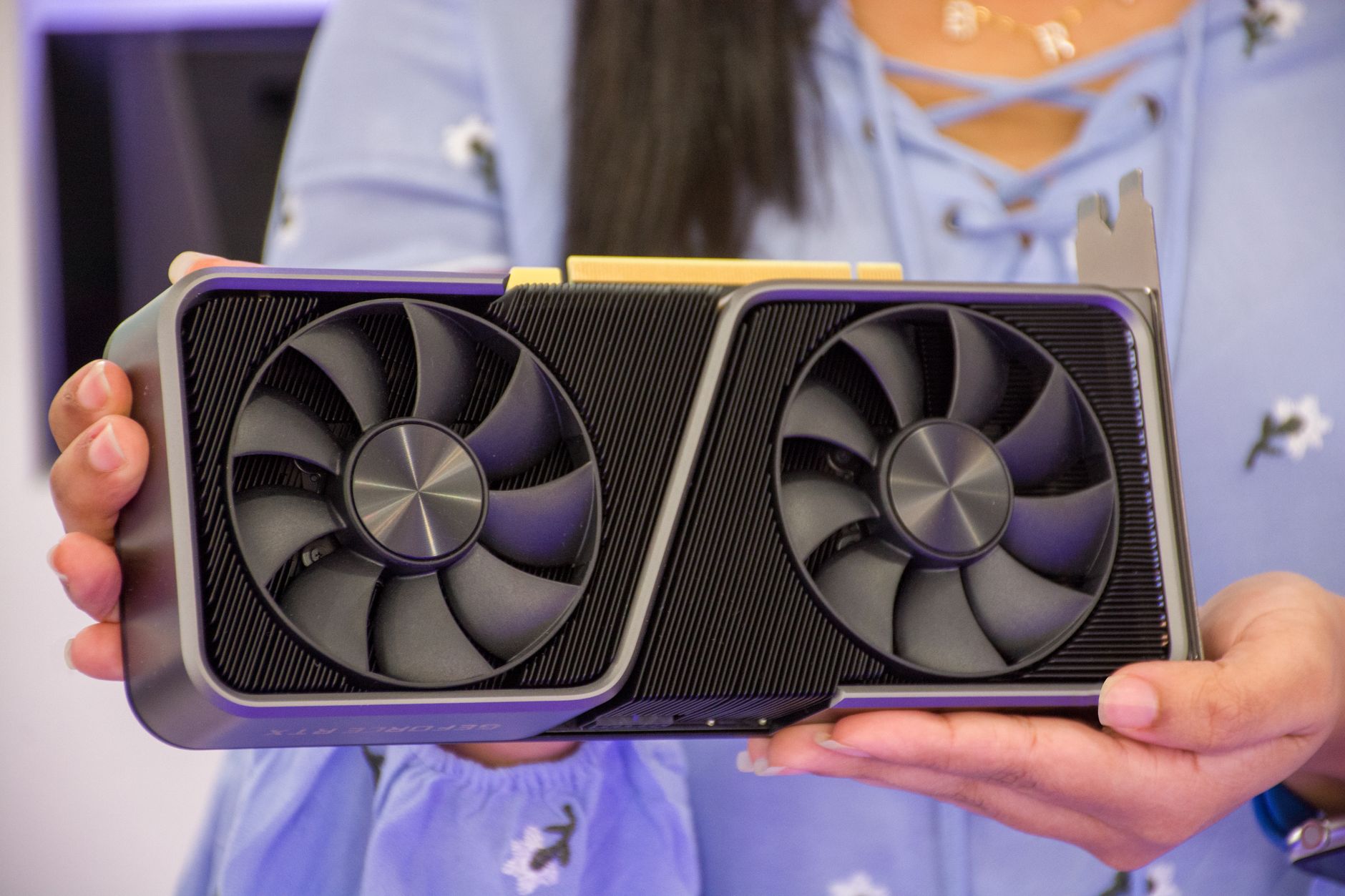 Hands holding a modern graphics card