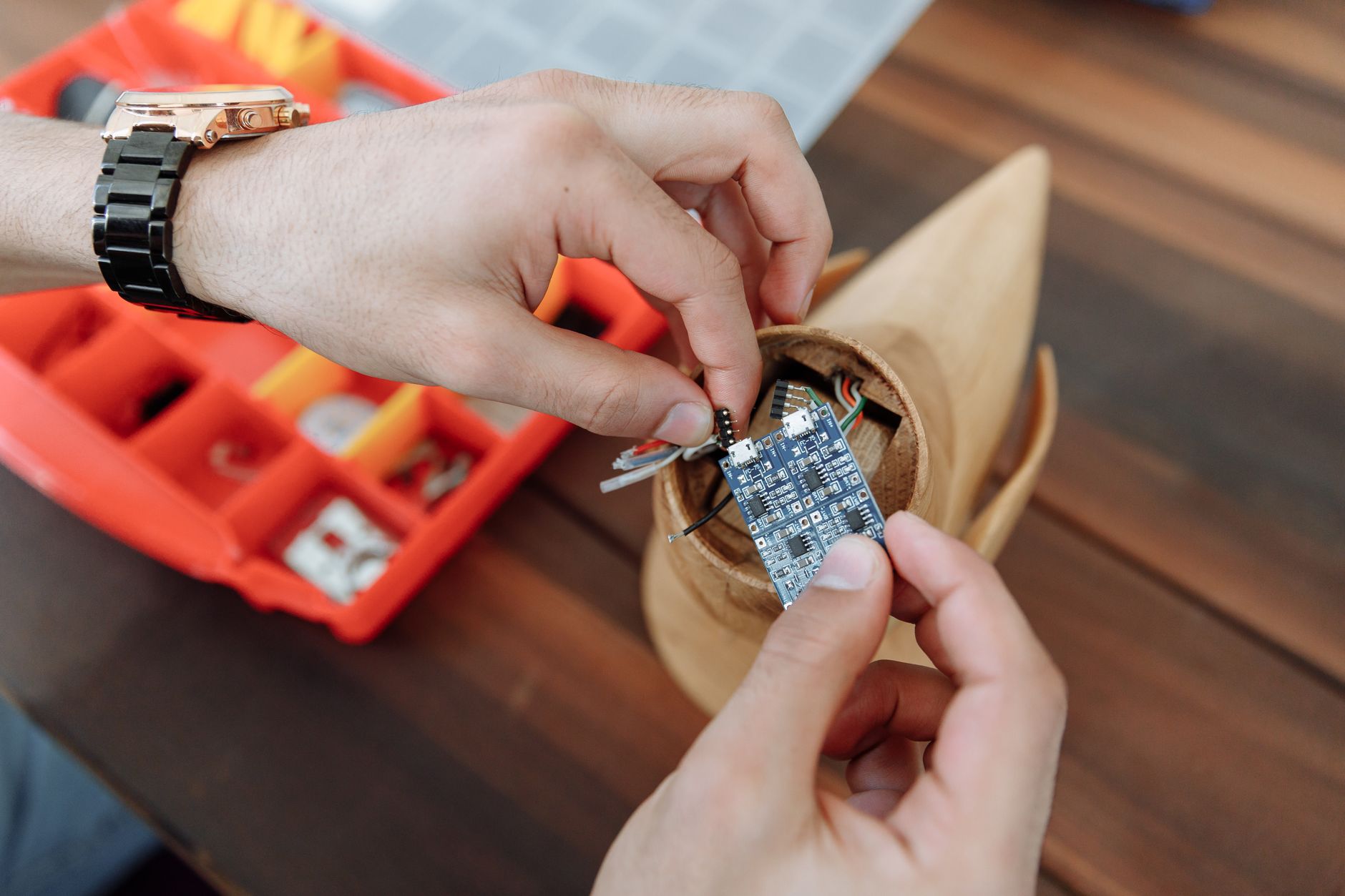 Hands working on a small microcontroller board