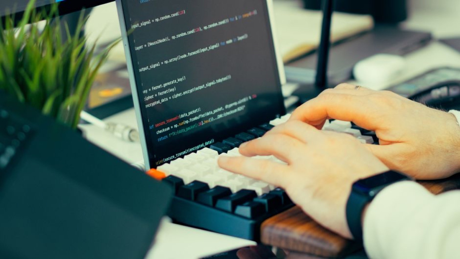 A developer typing code on a laptop