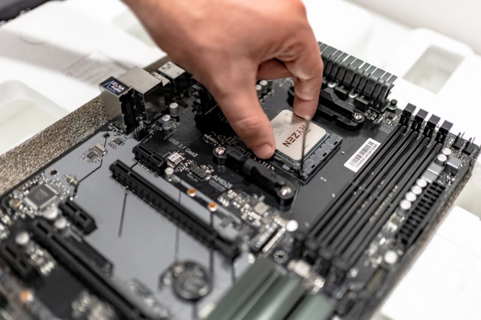 A hand installing a CPU on a motherboard