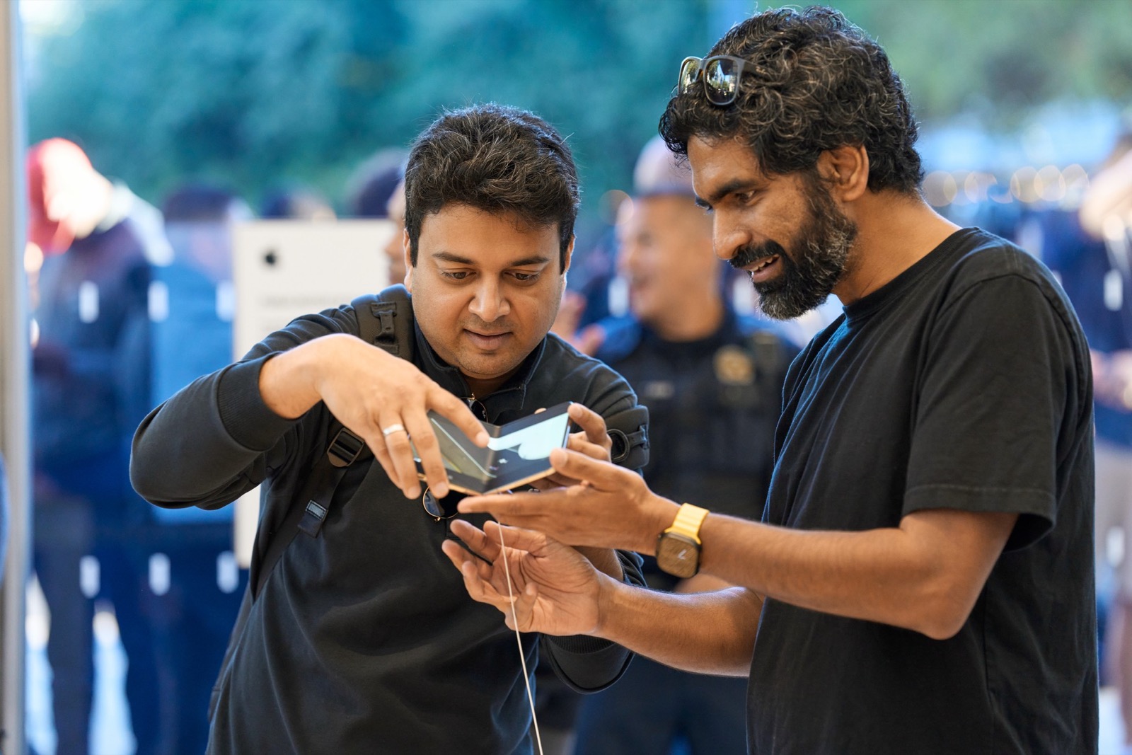 Two customers trying the iPhone Duo hinge at an Apple Store