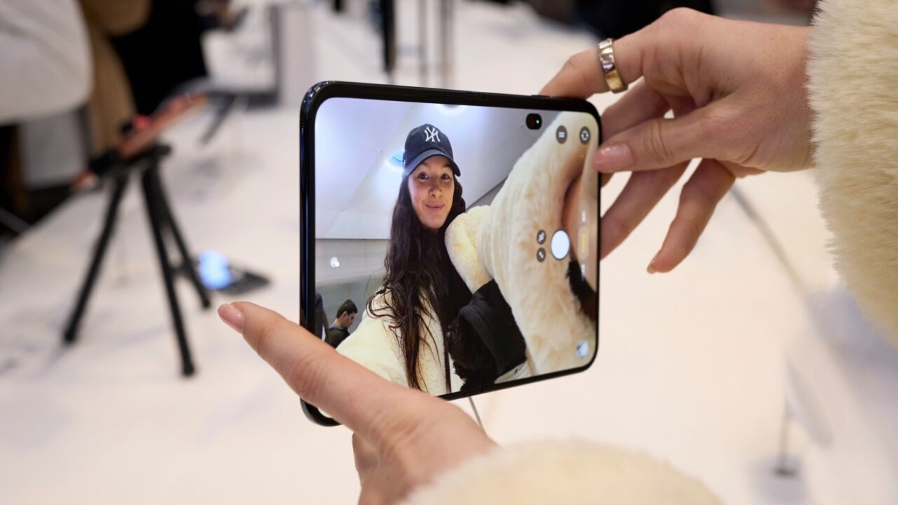 A customer holding an unfolded iPhone Duo in an Apple Store