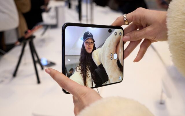 A customer holding an unfolded iPhone Duo in an Apple Store