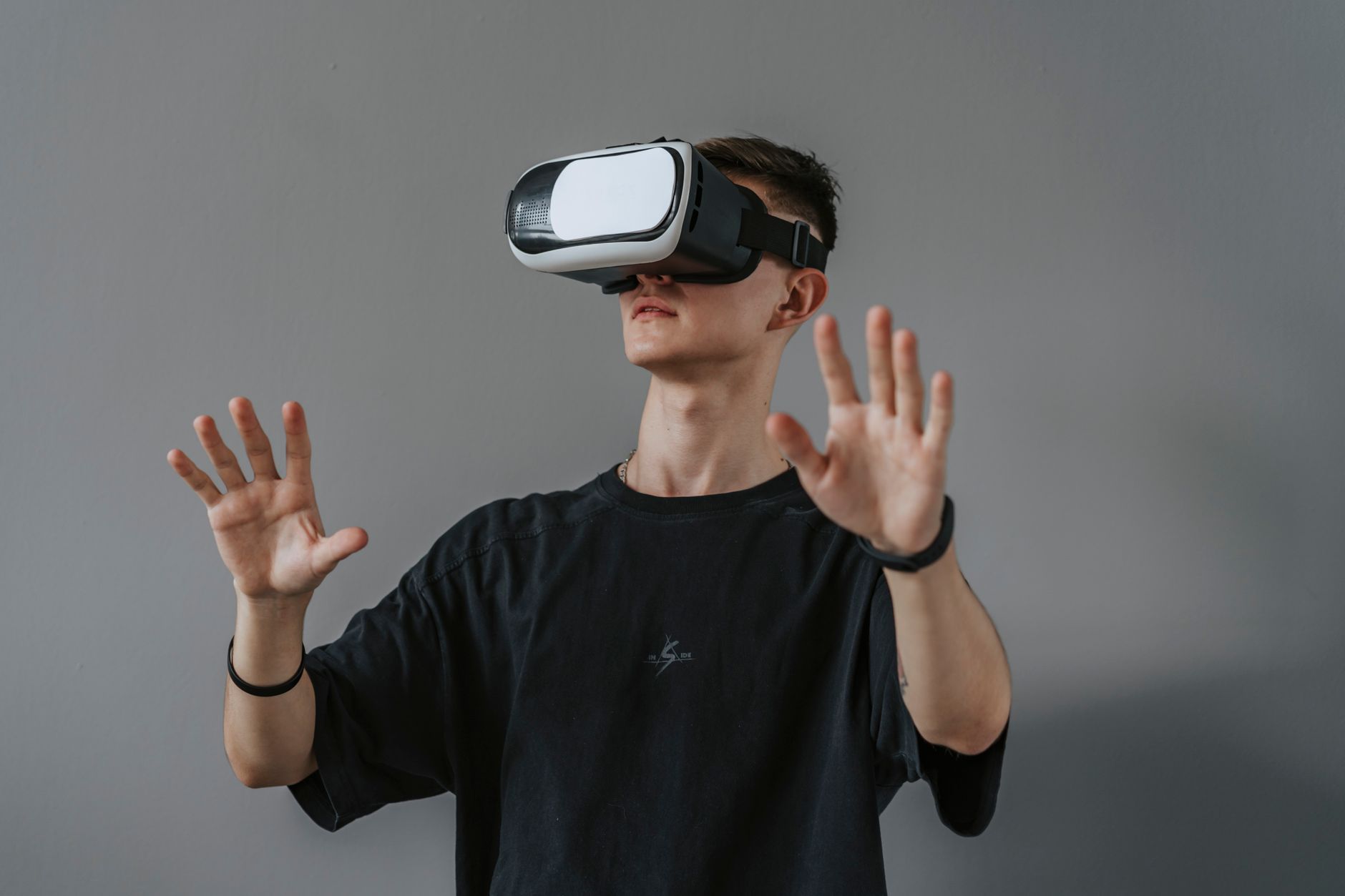 A man using a VR headset with his hands raised