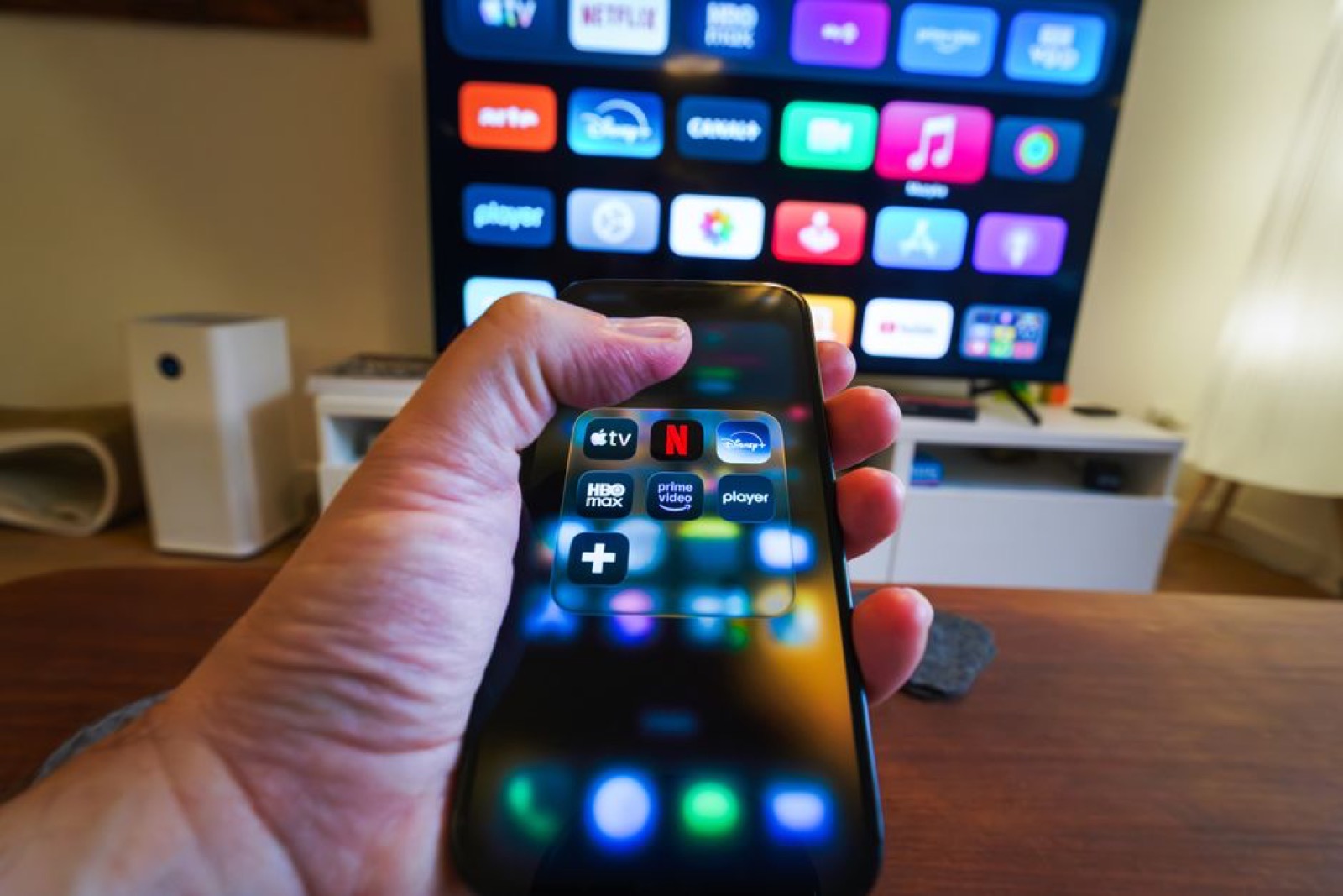 A hand holding a phone with streaming apps