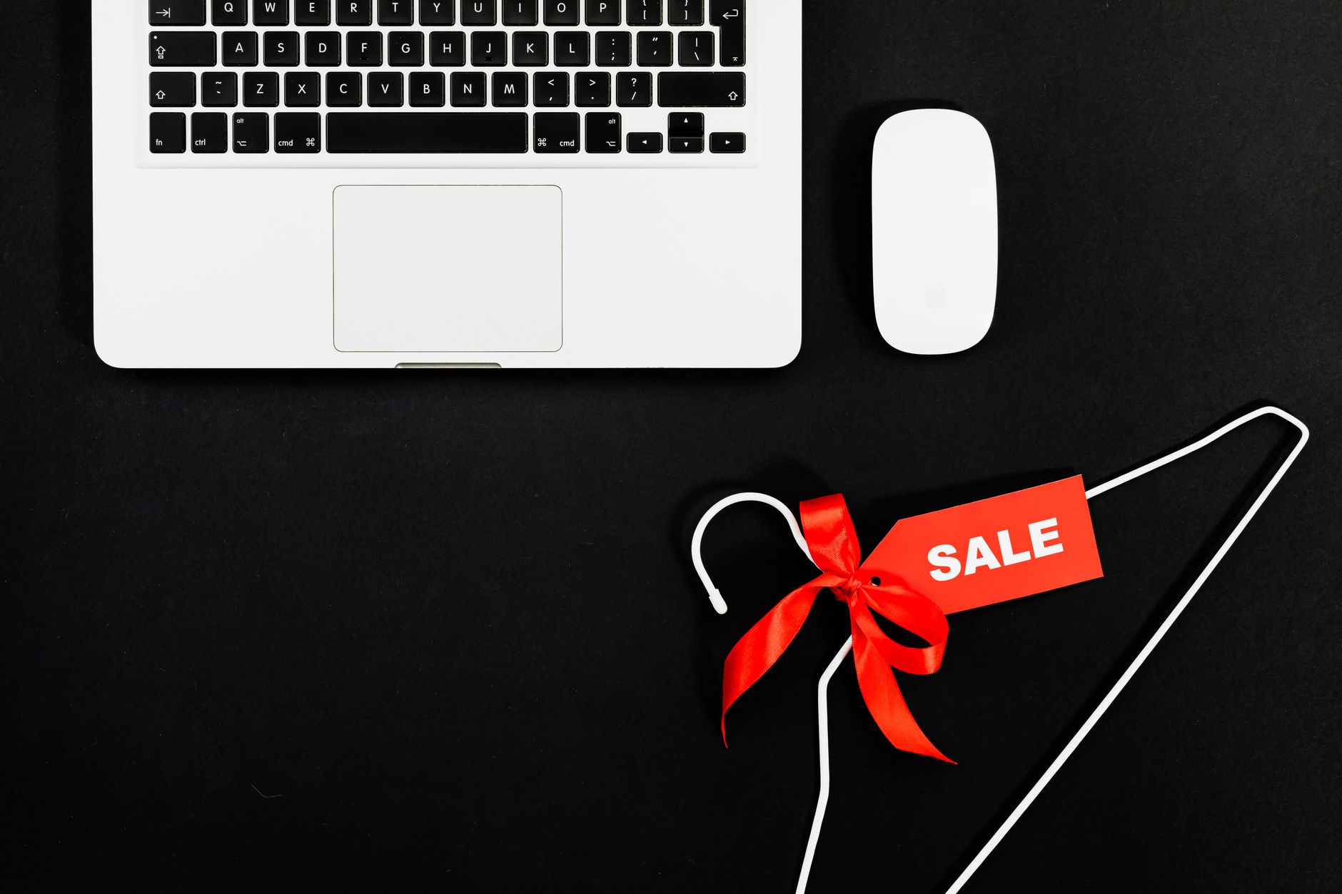 A laptop next to a red sale tag