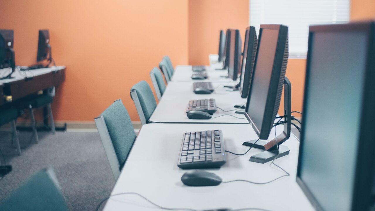 A row of desktop computers in an office