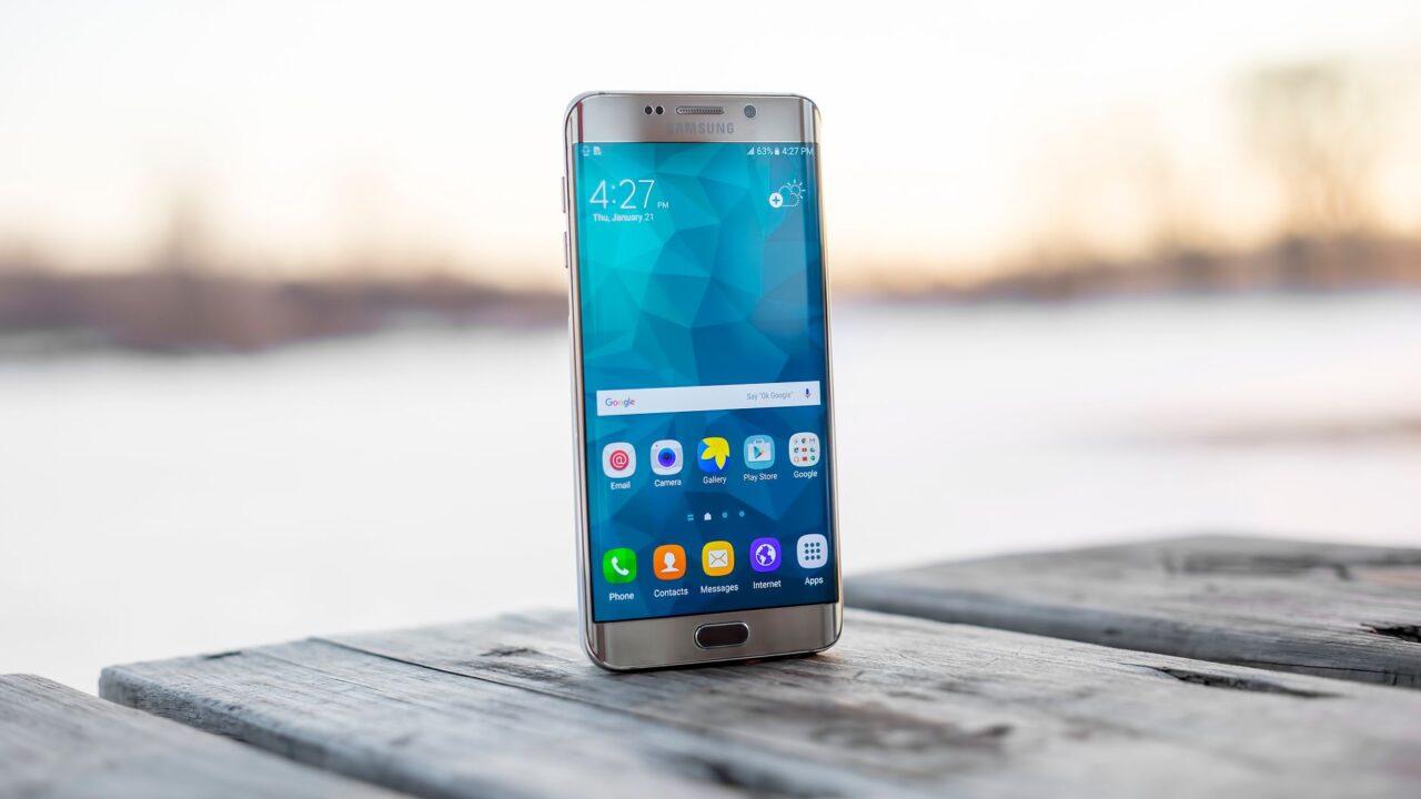 A Samsung Galaxy phone standing on a wooden surface