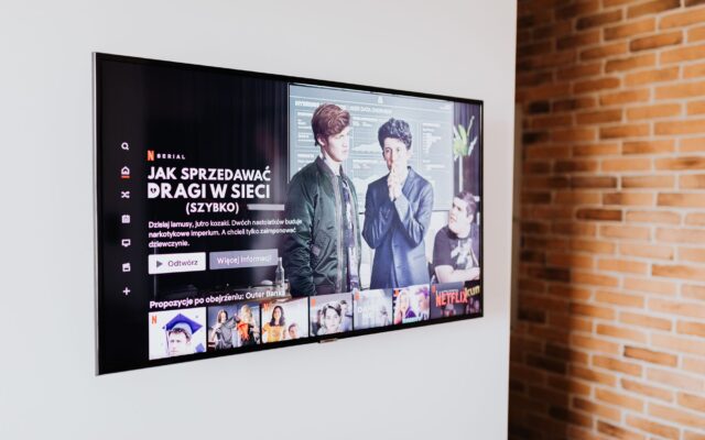 Smart TV displaying streaming content in modern living room setting with exposed brick wall.