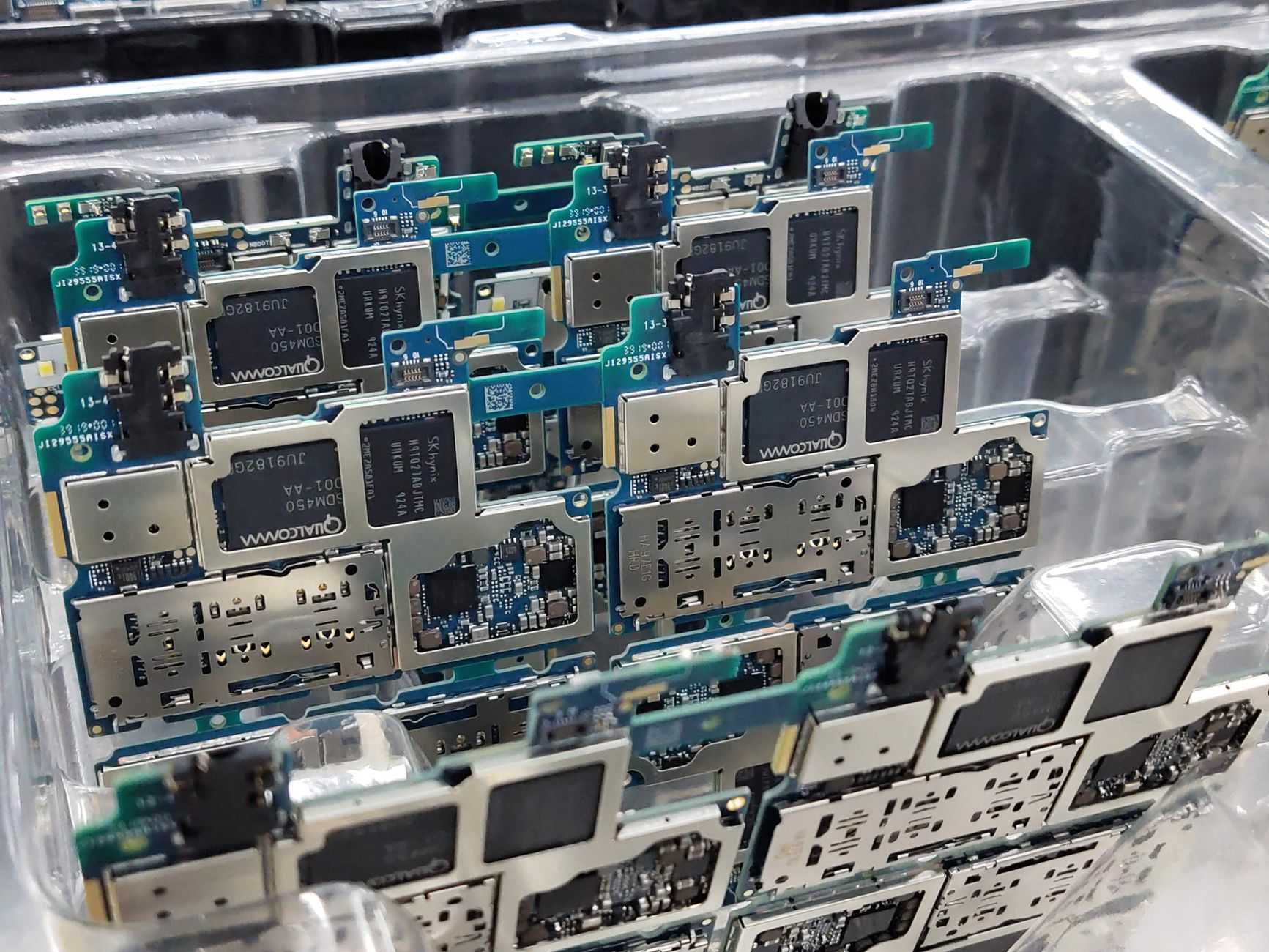 Smartphone circuit boards stacked in a tray at an electronics factory