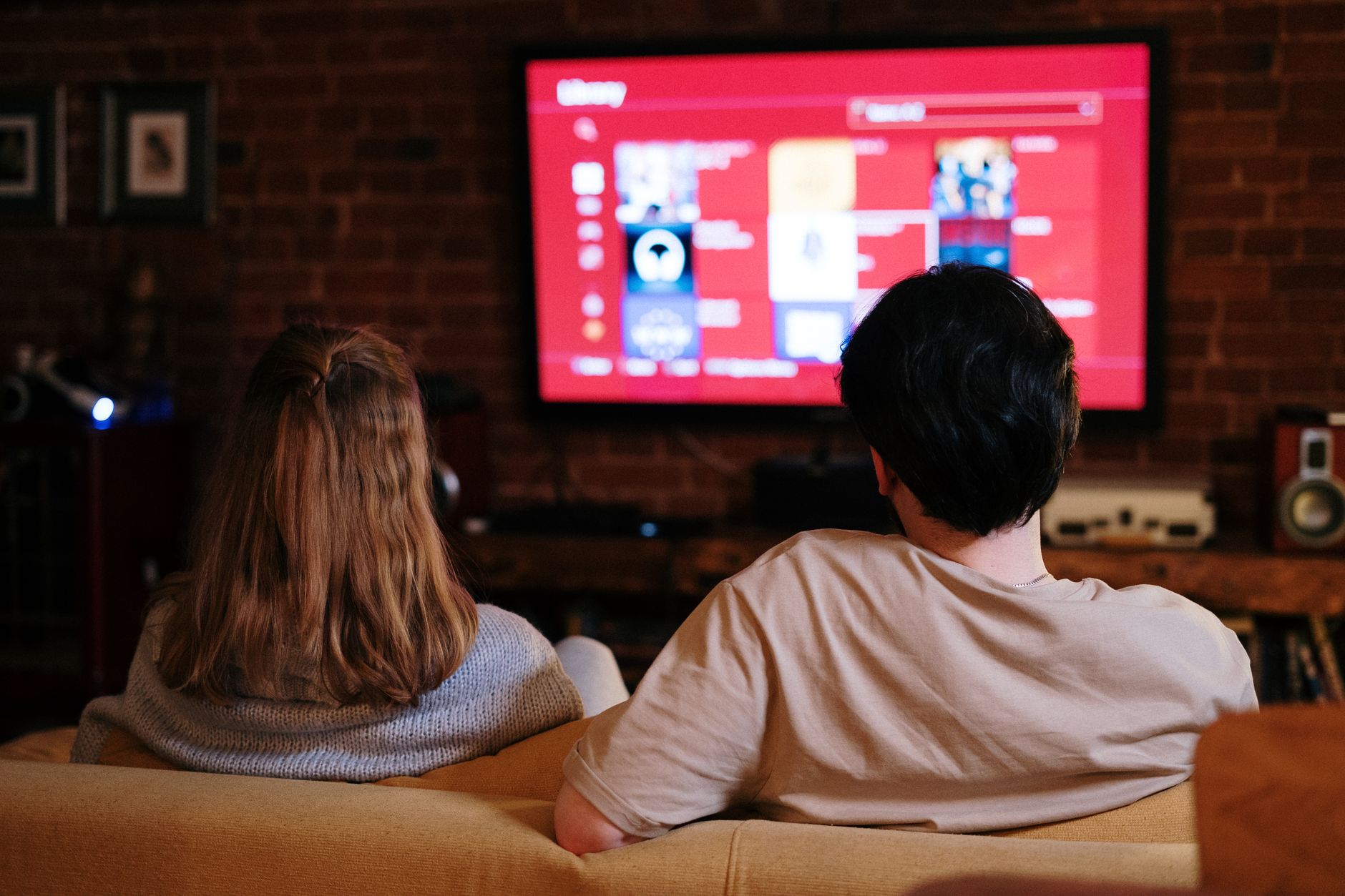 Two people streaming a show on a TV in their living room