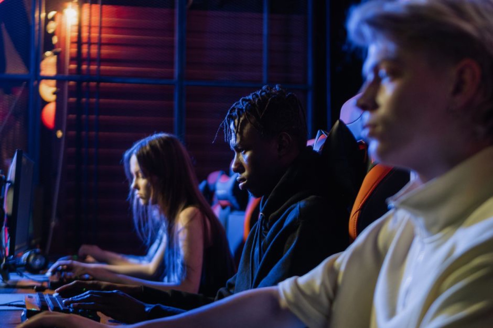 Three young gamers focused on their PCs