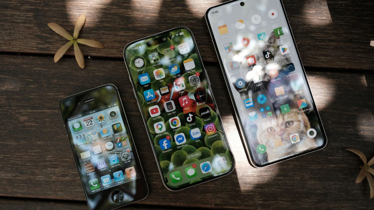 Three smartphones lying on a wooden table